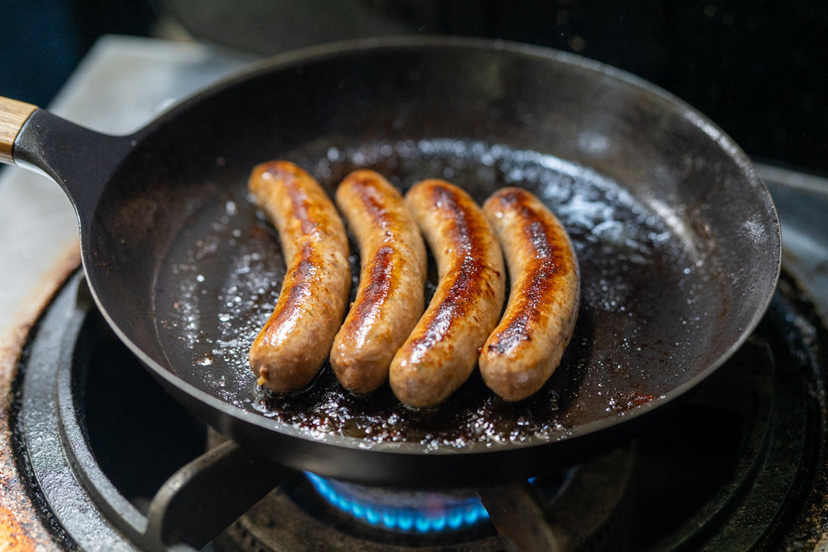 フライパンで焼かれている4本のソーセージ