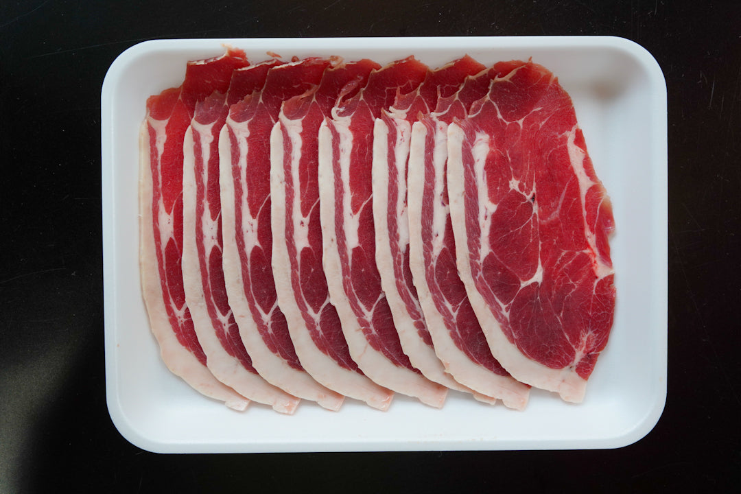 白いトレーに重ねて並べた薄切り肉