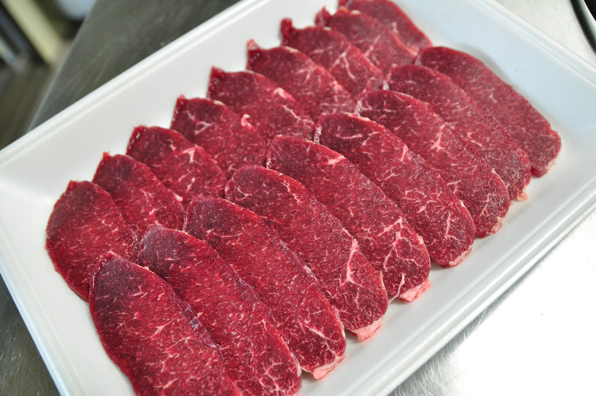 白いトレーに整然と並べた赤身肉の薄切り
