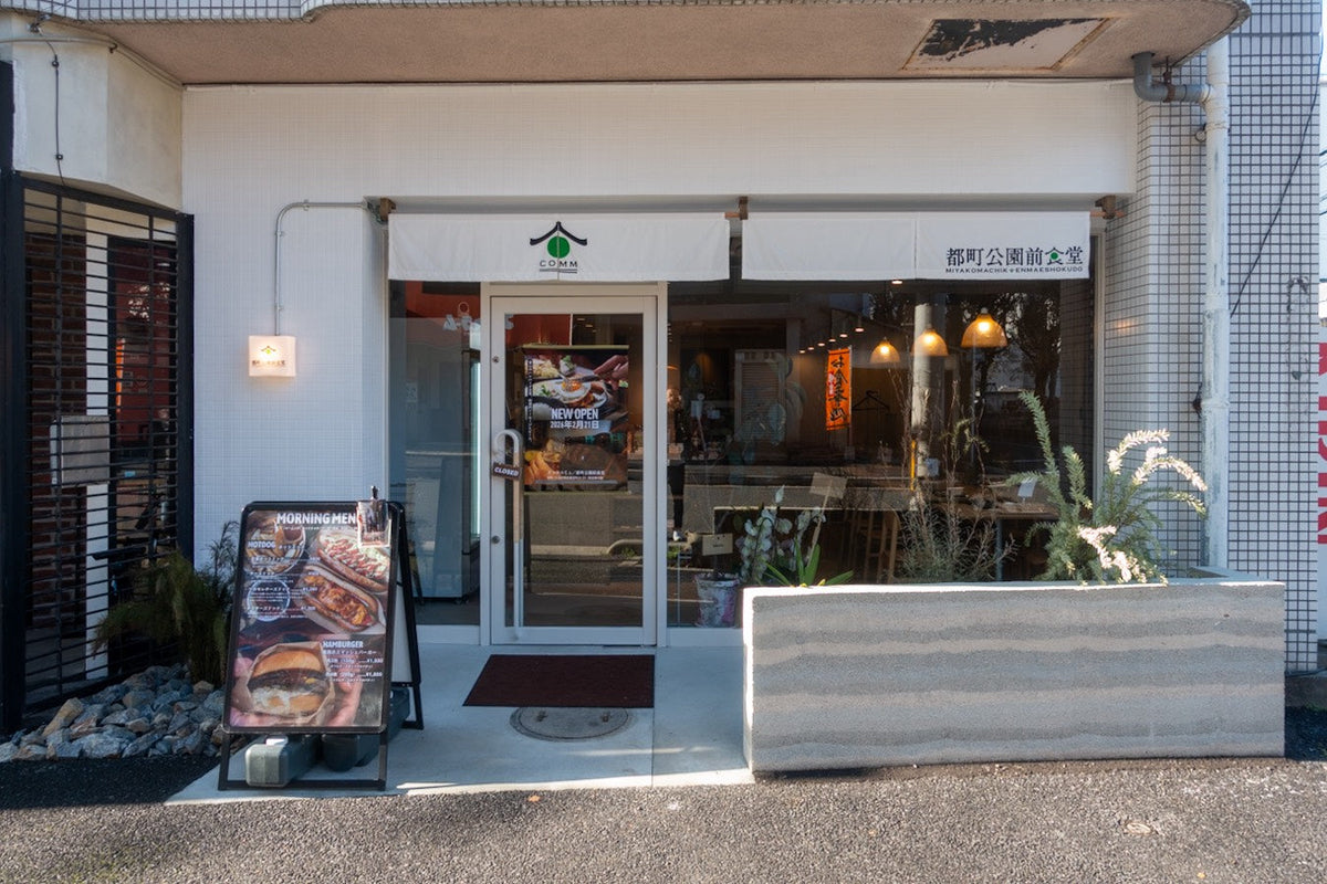昼間の「都町公園前食堂」の外観と、店頭のメニュー看板